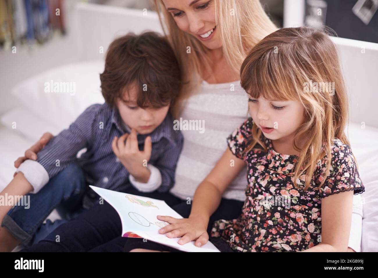 Family bonding time. a mother reading with her children at home. Stock Photo