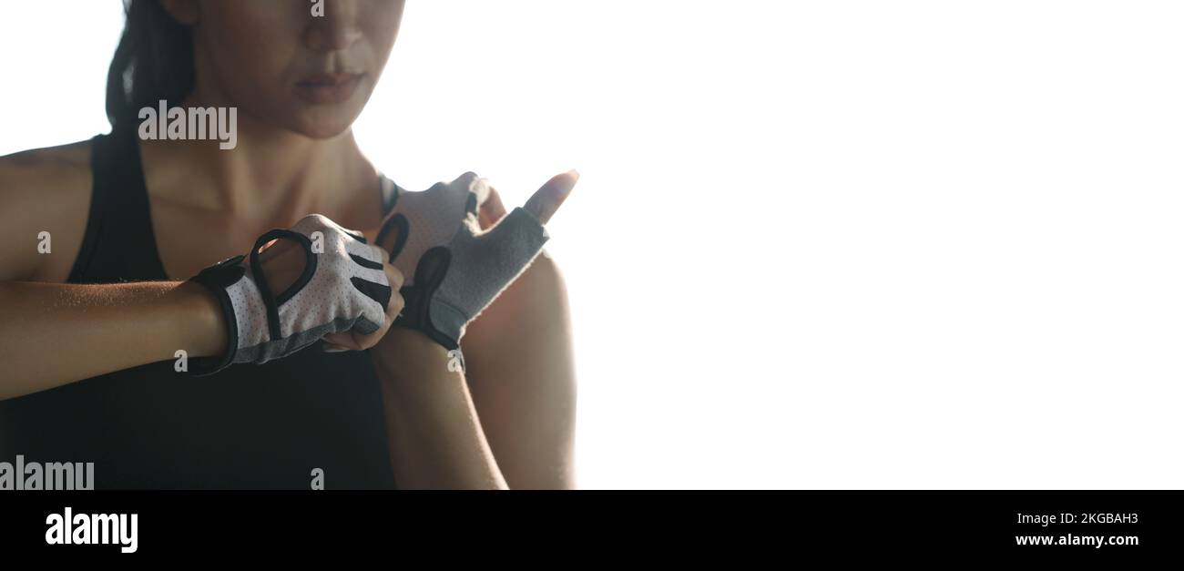 Woman put fitness gloves  for exercise at gym. Stock Photo