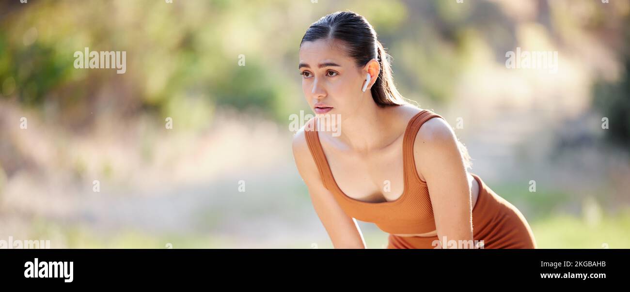 Tired runner, fitness and woman stop from exercise for break, breathing and rest while running in a park. Workout, rest and sports girl challenge Stock Photo