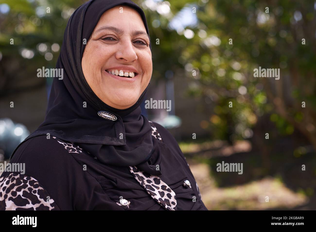 Living and laughing. Portrait of a mature muslim woman standing outside. Stock Photo