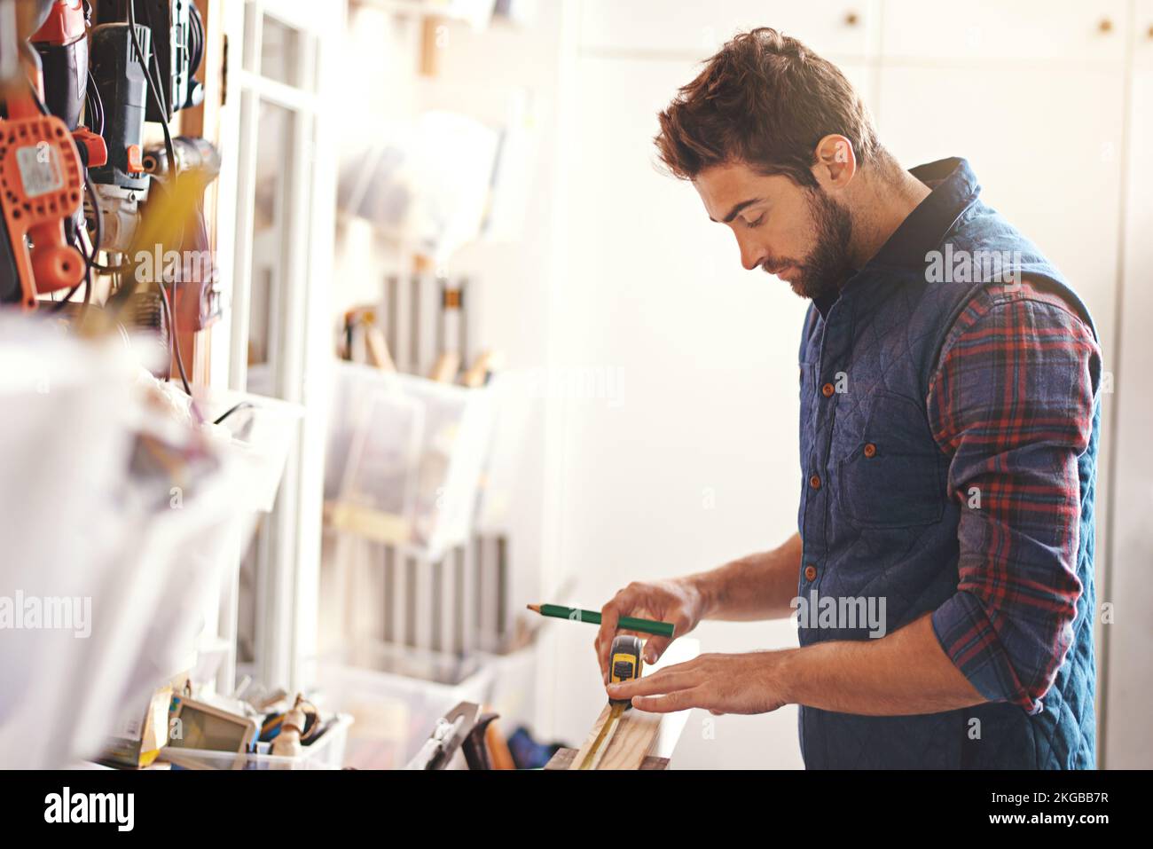 Making careful measurements. a carpenter making measurements on a plank