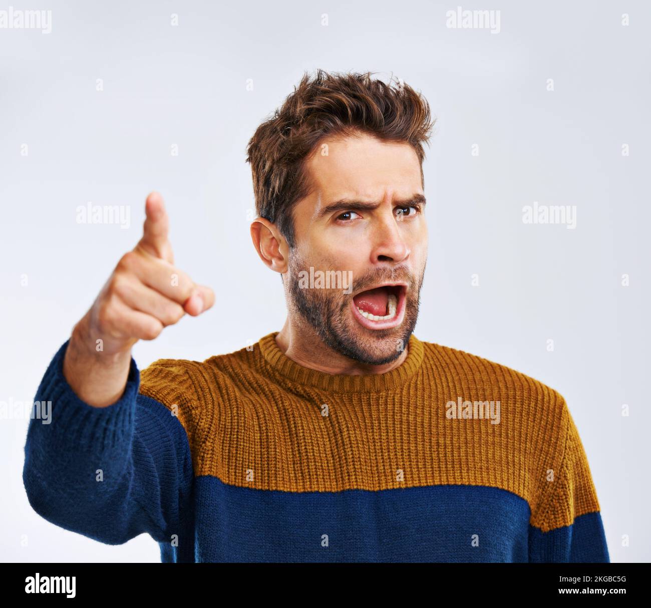 You better run. Studio shot of an angry young man pointing and yelling