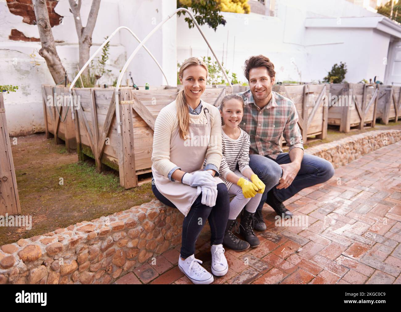 Living organic and healthy. Portrait of a happy family taking a break from their gardening in the their backyard. Stock Photo