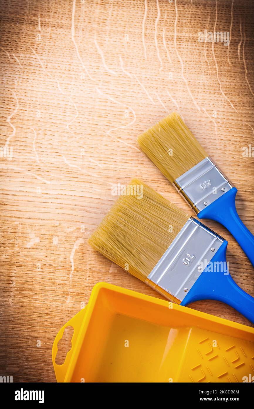 aerial view two paintbrushes with blue handles and yellow paint can on ...