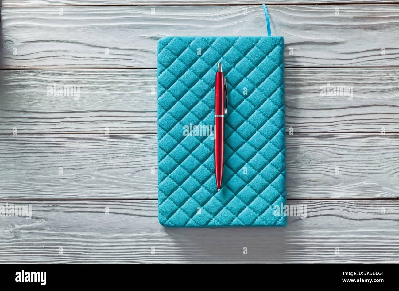 blue classic soft notepad and red ball point pen on vintage painted ...