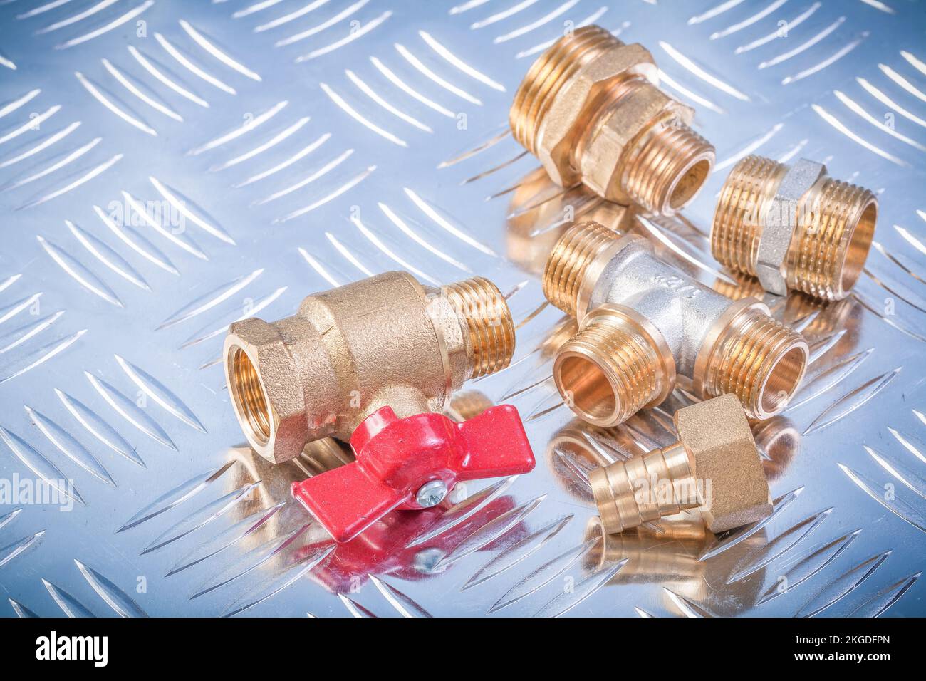 Brass nipple hose connectors equal tee check water valve on grooved metal background plumbing concept. Stock Photo