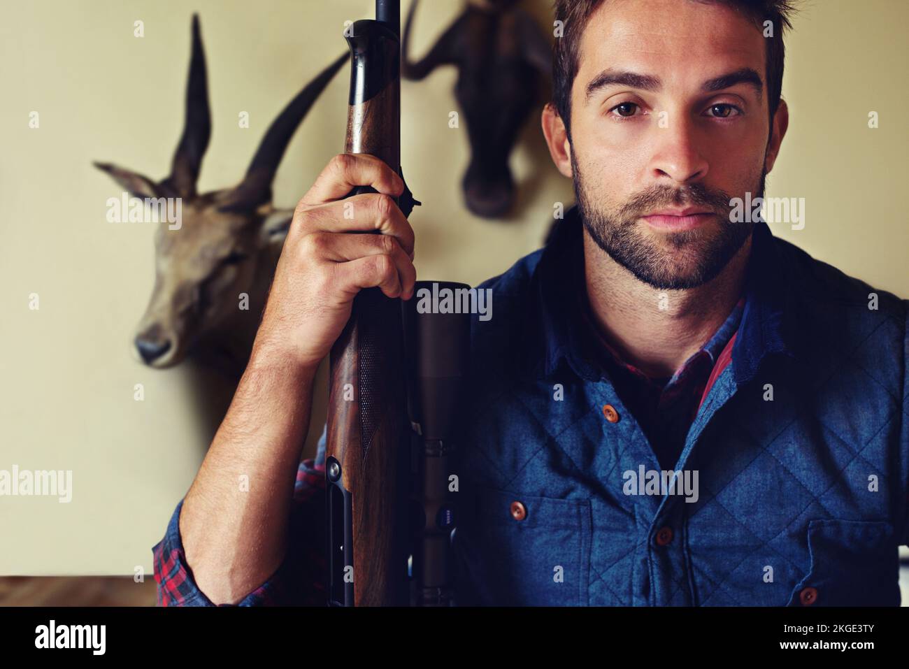 Life of a hunter. Portrait of a hunter standing in front of his trophies. Stock Photo