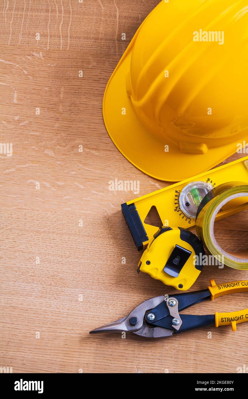 Hard hat nippers duct tape construction level and measuring tape on wood board Stock Photo Alamy