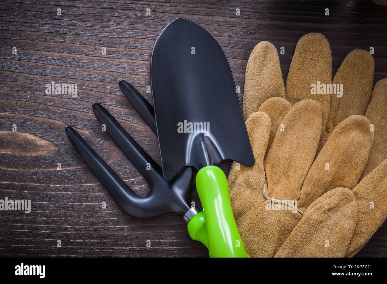 Leather safety gloves metal hand spade and trowel fork on vintage
