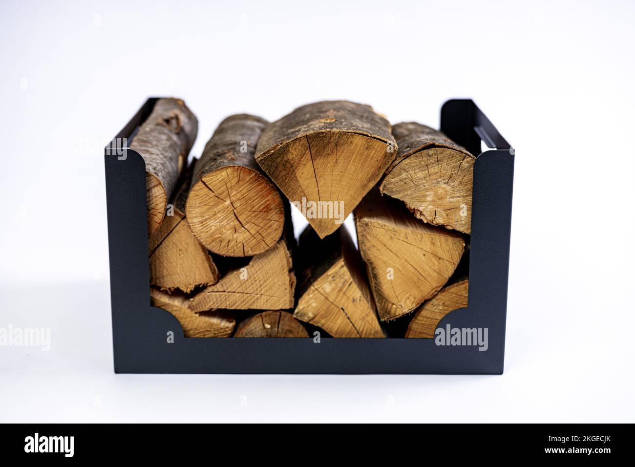 A metal box for firewood with wood logs in it on white background in a