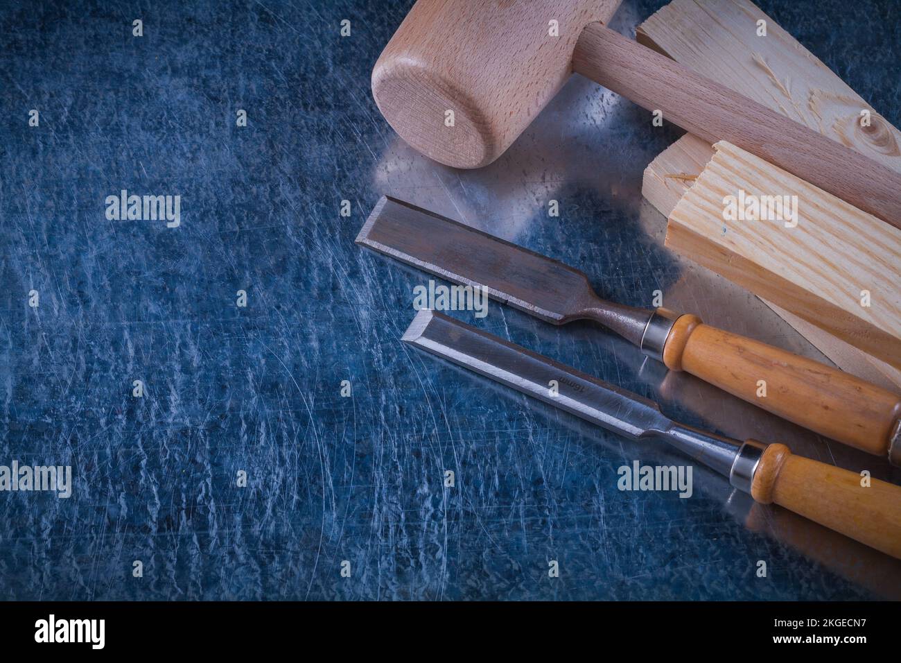 Lump hammer wooden studs and flat chisels on scratched metallic background construction concept. Stock Photo