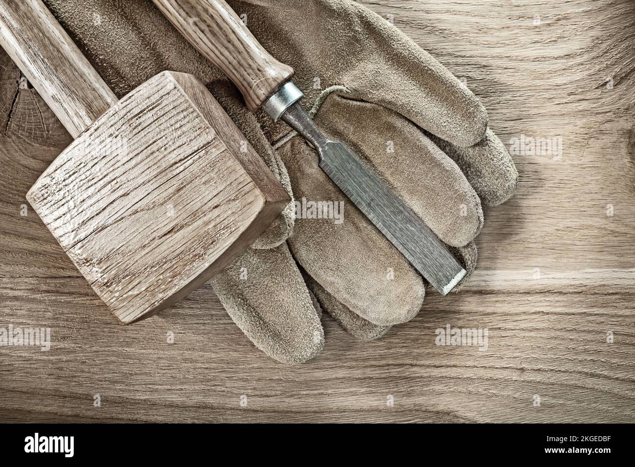 Lump hammer chisel leather protective gloves on wood board. Stock Photo