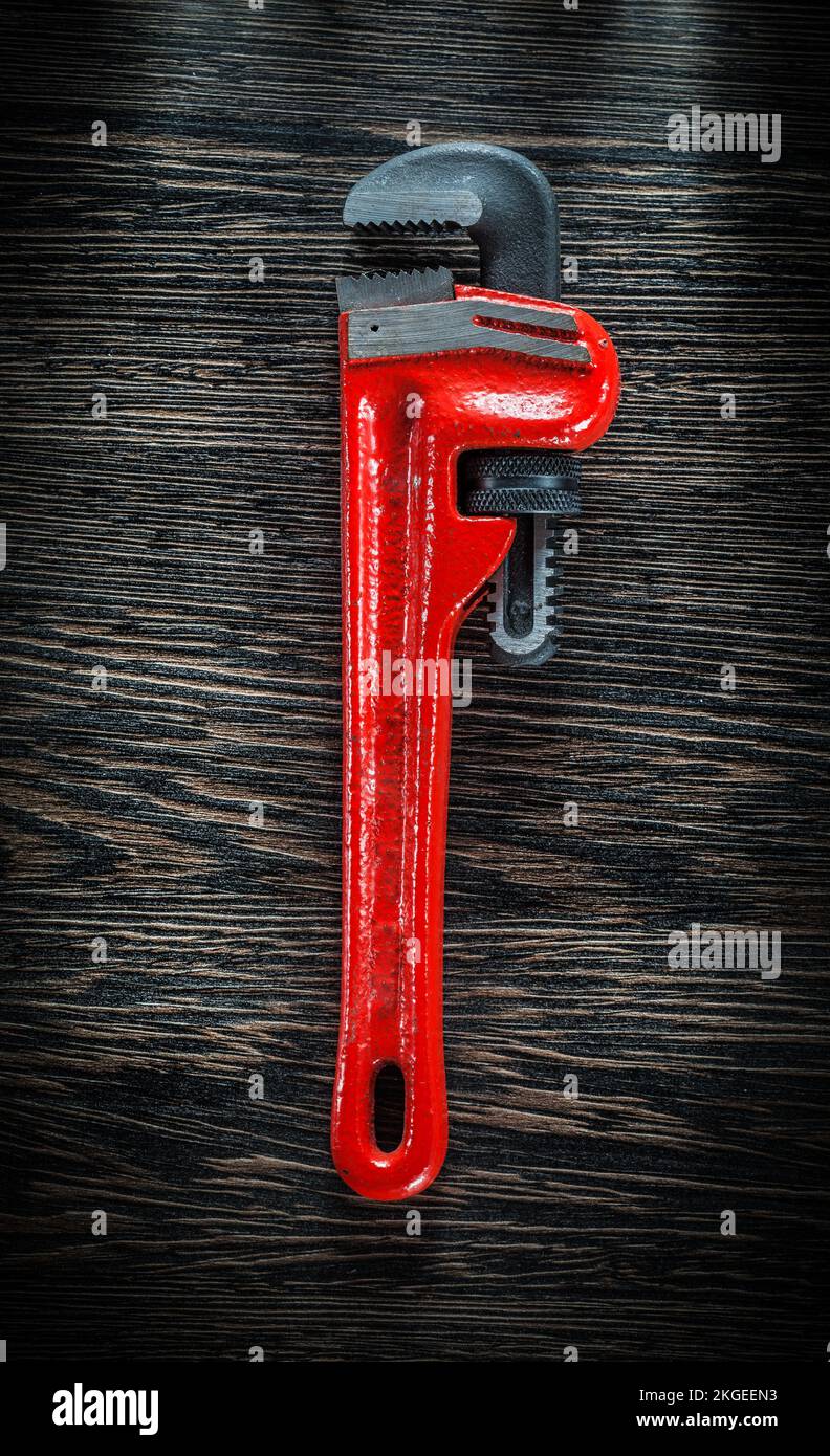 Monkey wrench on vintage wooden board. Stock Photo