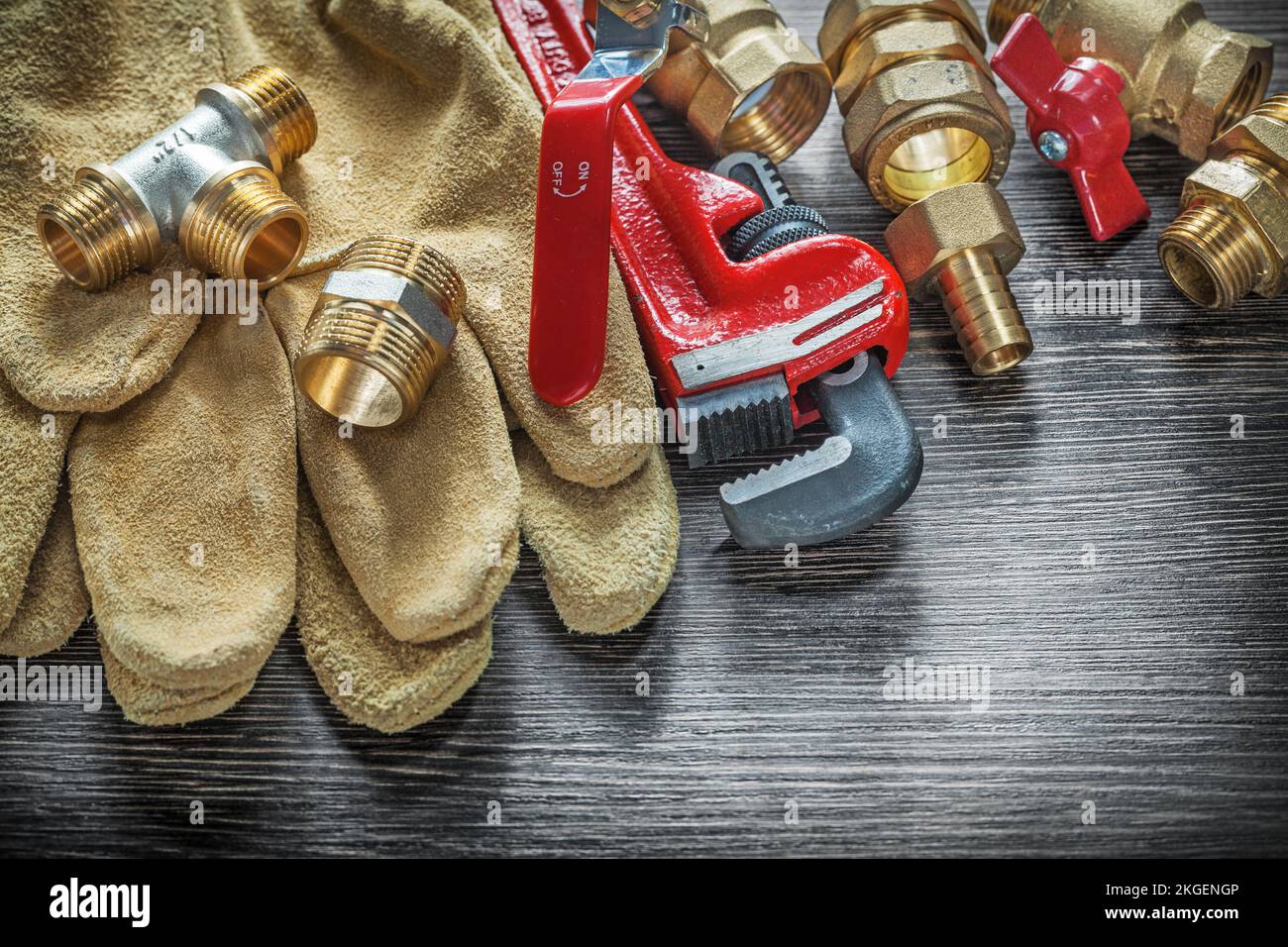 Pipe wrench connectors safety gloves water valves on wooden board Stock ...