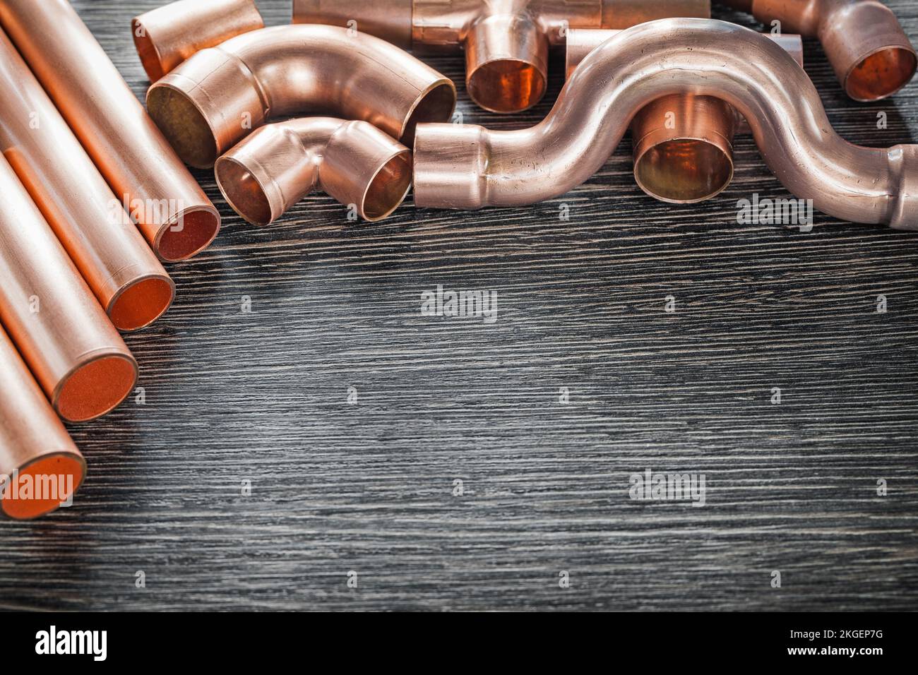Plumbing brass water pipe fittings on wooden board. Stock Photo