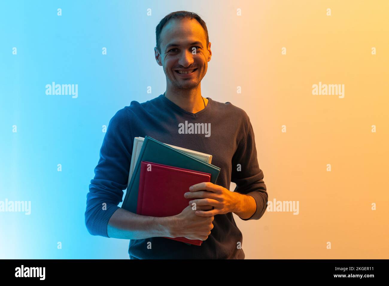 Photo of dreamy charming young man look empty space hold hug book novel isolated on color background Stock Photo