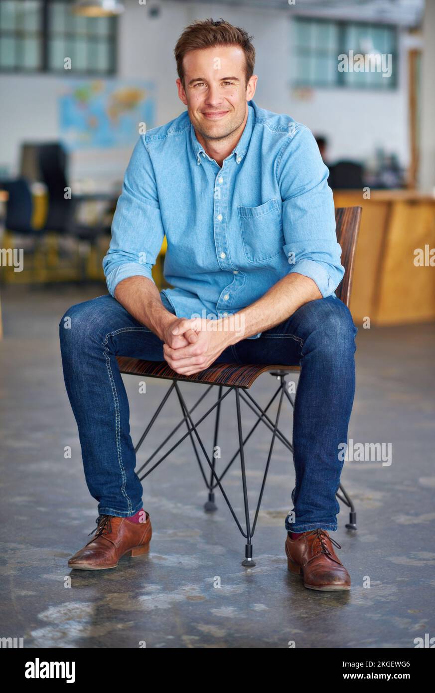 Getting this position was the best opportunity ever. Portrait of a handsome young designer sitting on a chair in an office. Stock Photo