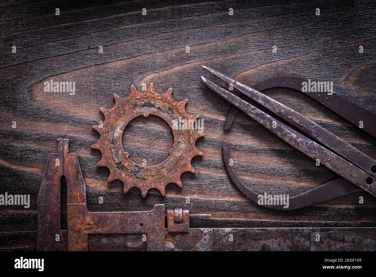 Rusted antique measuring calipers with gear wheel on vintage dark