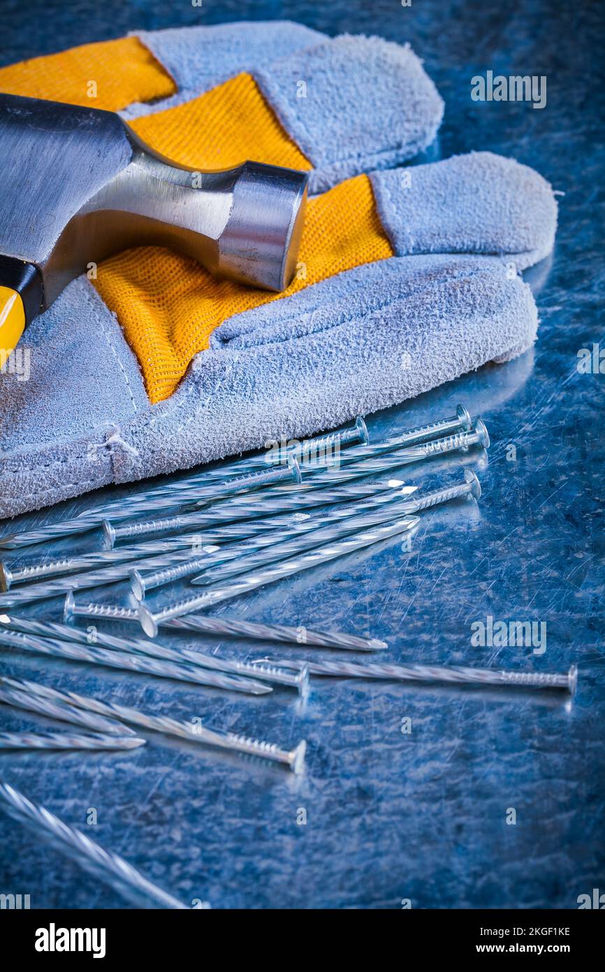 Safety glove construction nails and claw hammer on scratched metallic