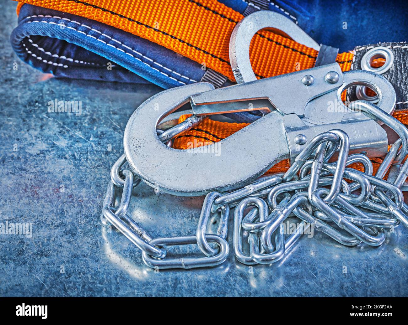 Safety harness metal chain carabiner hook on metallic background Stock