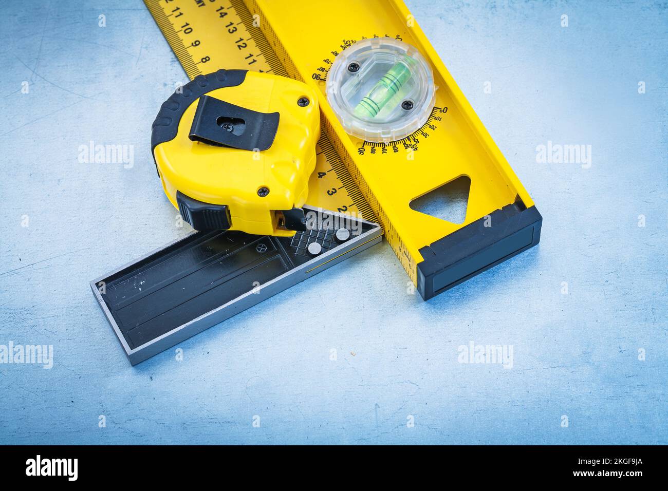 Tape line construction level and square ruler on metallic background ...