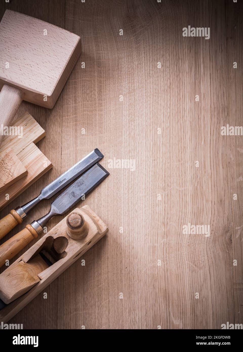 Vertical view of lump hammer shaving plane metal chisels and wooden planks on wood board construction concept. Stock Photo