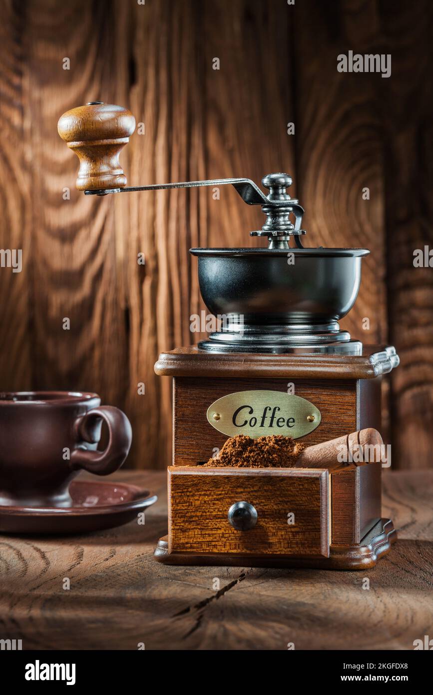vertical view vintage wooden coffee mill with little scoop and cup on