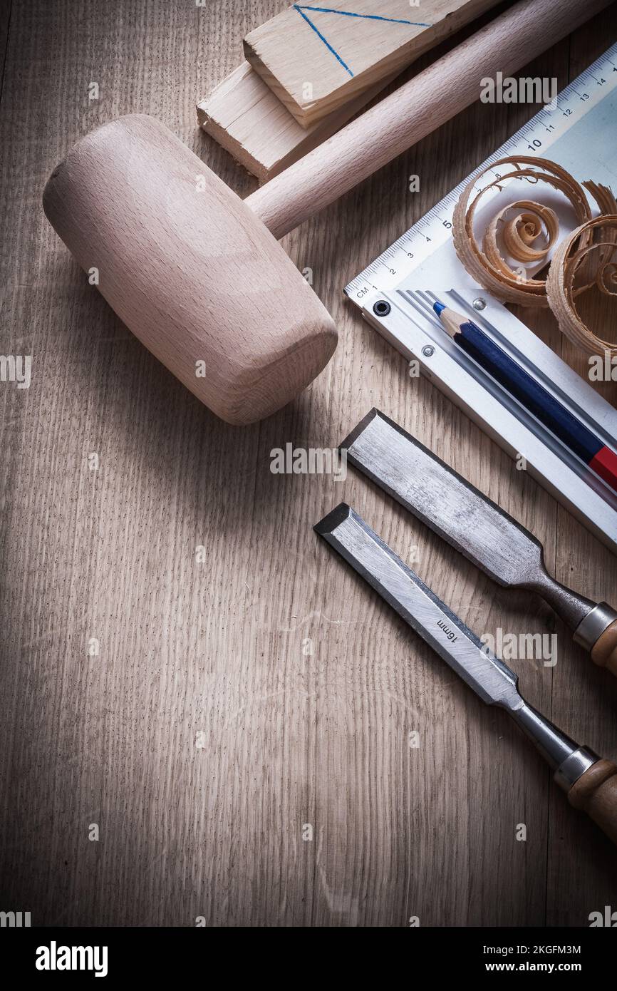 Wooden bricks hammer curled up planning chips chisels try square pencil on wood board construction concept. Stock Photo