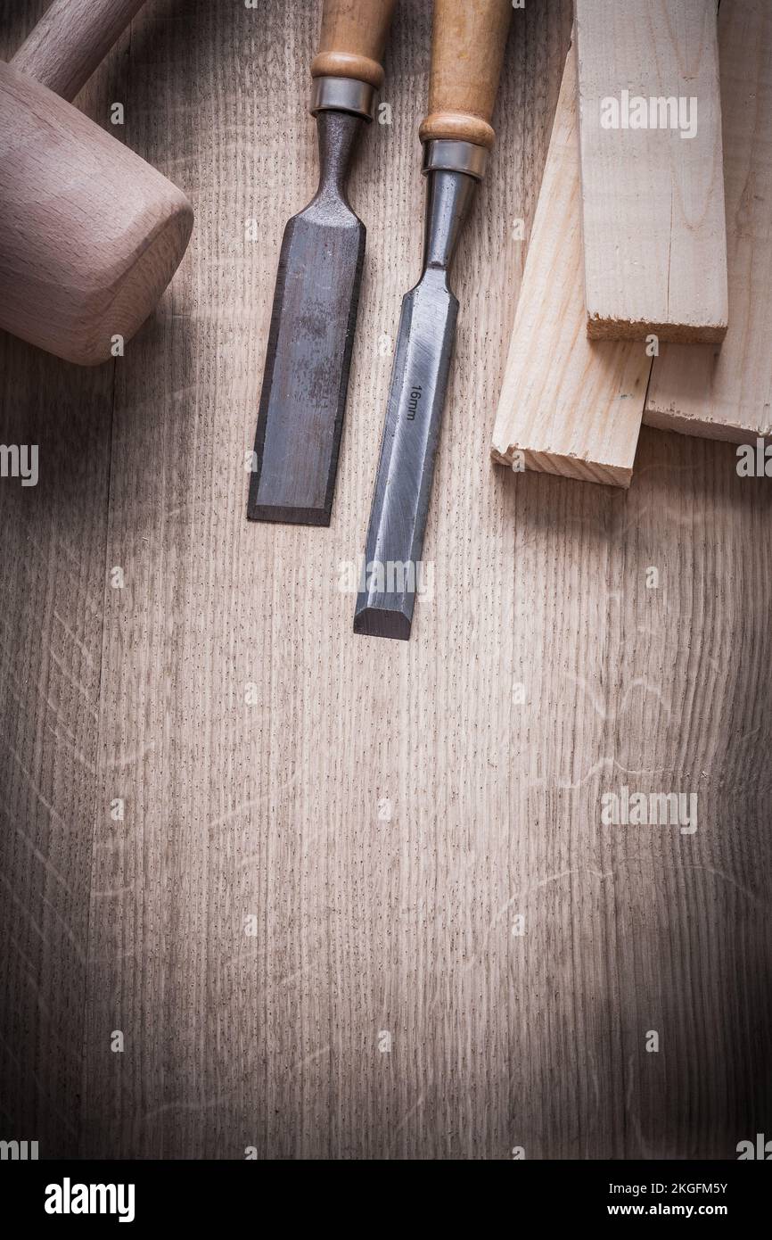Wooden bricks hammer carpenter’s firmer chisels on wood background vertical version construction concept. Stock Photo