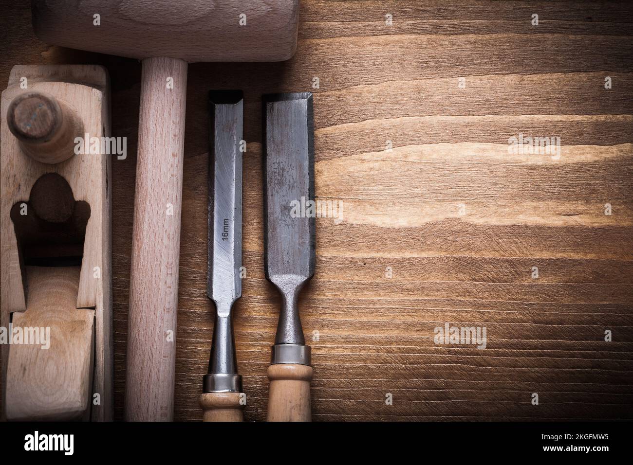 Wooden hammer shaving plane flat chisels on wood board construction concept. Stock Photo
