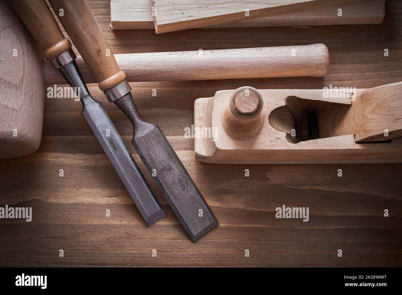 Wooden hammer planner chisels building planks on wood board construction concept. Stock Photo