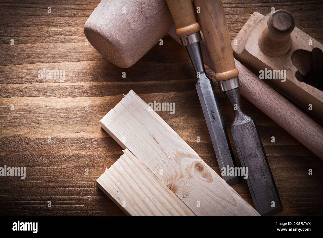 Wooden mallet planner chisels building planks on wood board construction concept. Stock Photo