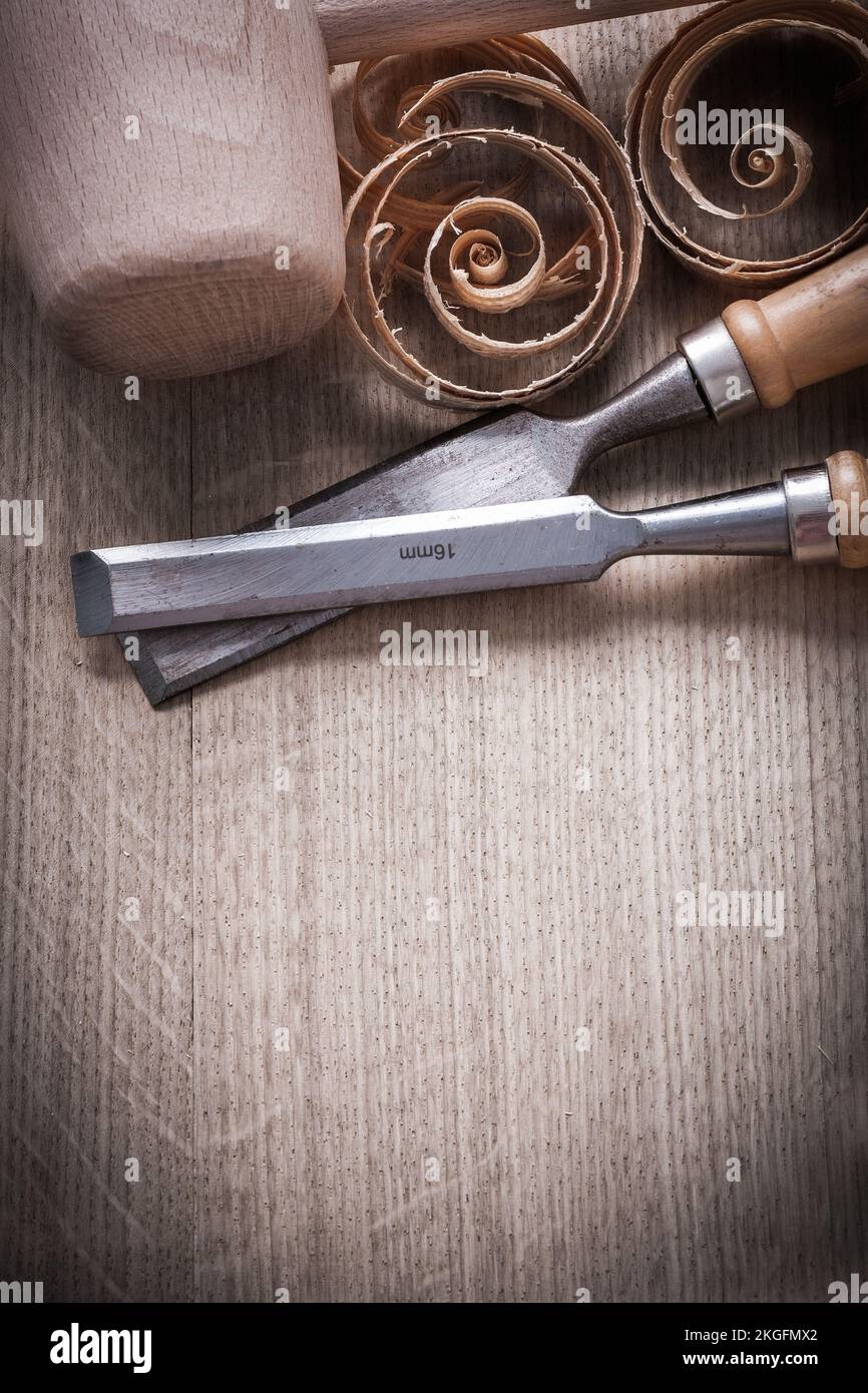 Wooden hammer planning chips flat chisels on wood surface construction concept. Stock Photo