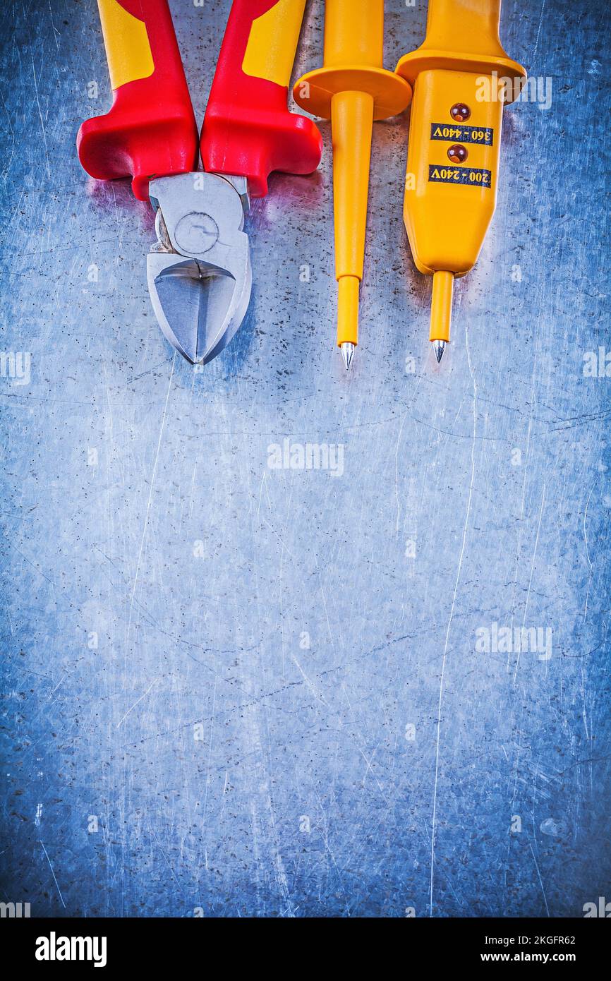 Yellow electrical tester cutting pliers on metallic background ...
