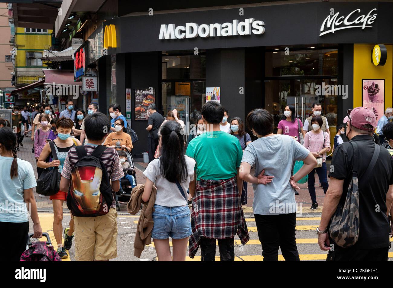 Hong Kong, China. 23rd Nov, 2022. Pedestrians wait at a traffic light in front of the American multinational fast-food hamburger restaurant chain, McDonald's and McCafe in Hong Kong. Credit: SOPA Images Limited/Alamy Live News Stock Photo