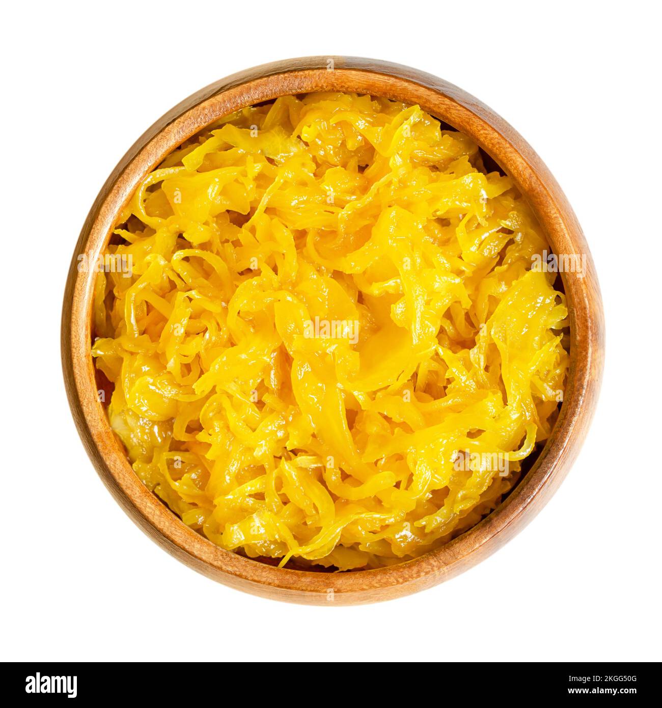 Sweet golden curry mango sauerkraut, in a wooden bowl. Finely cut cabbage, fermented by lactic acid bacteria, with added mango puree and curry powder. Stock Photo