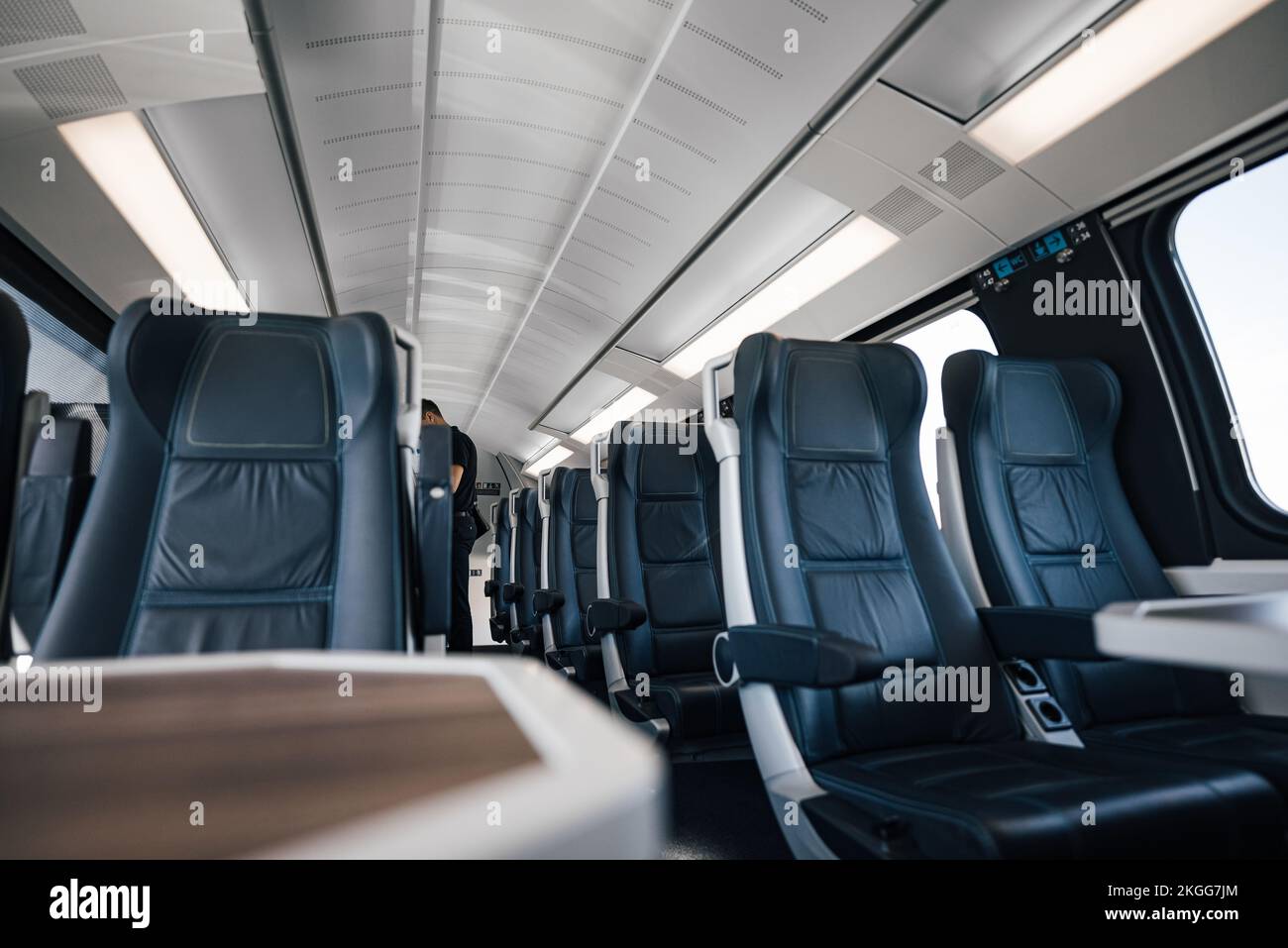 Passenger is standing amidst empty seats. Interior of modern