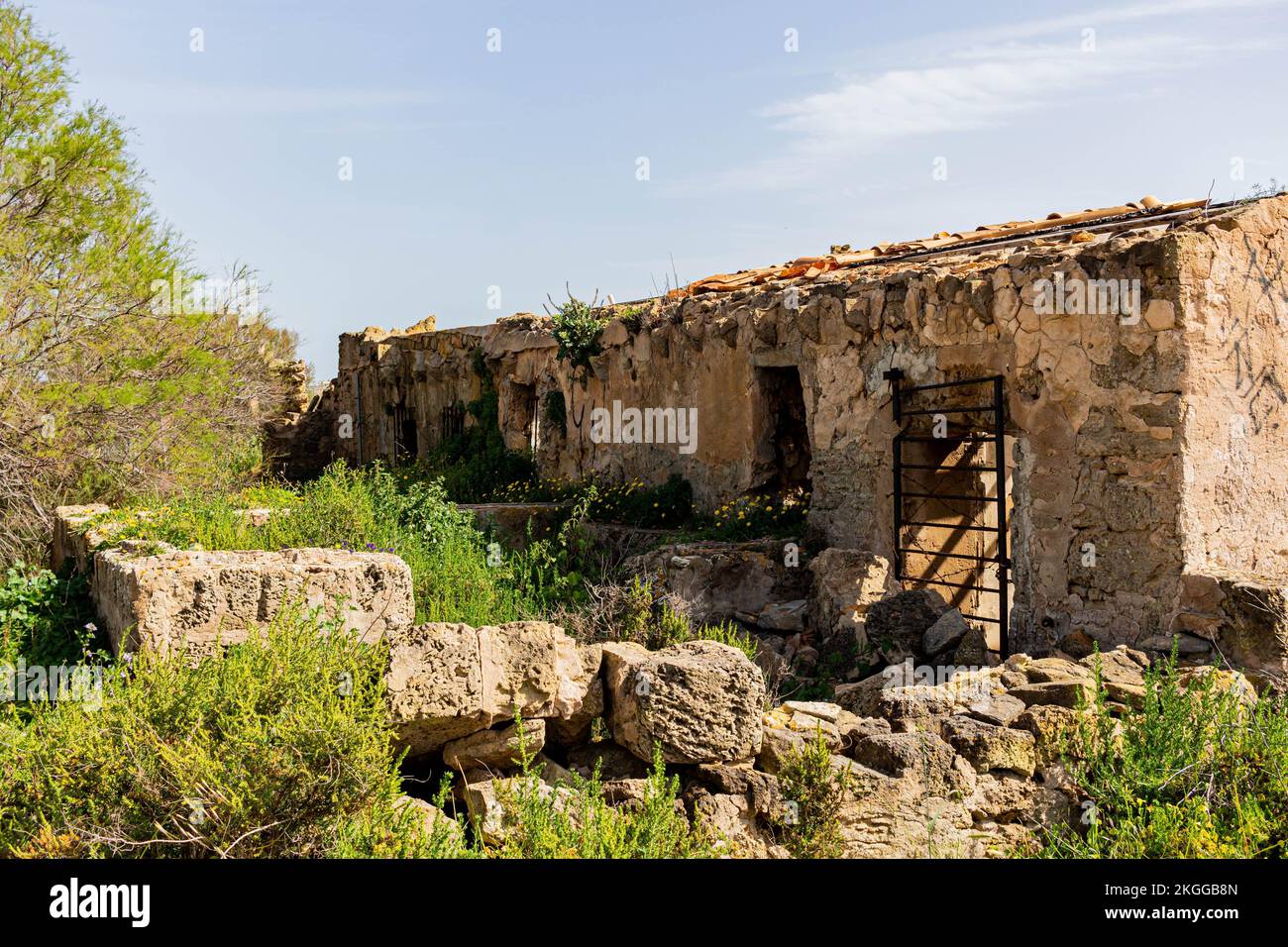 A ruined building surrounded by green vegetation against the background ...
