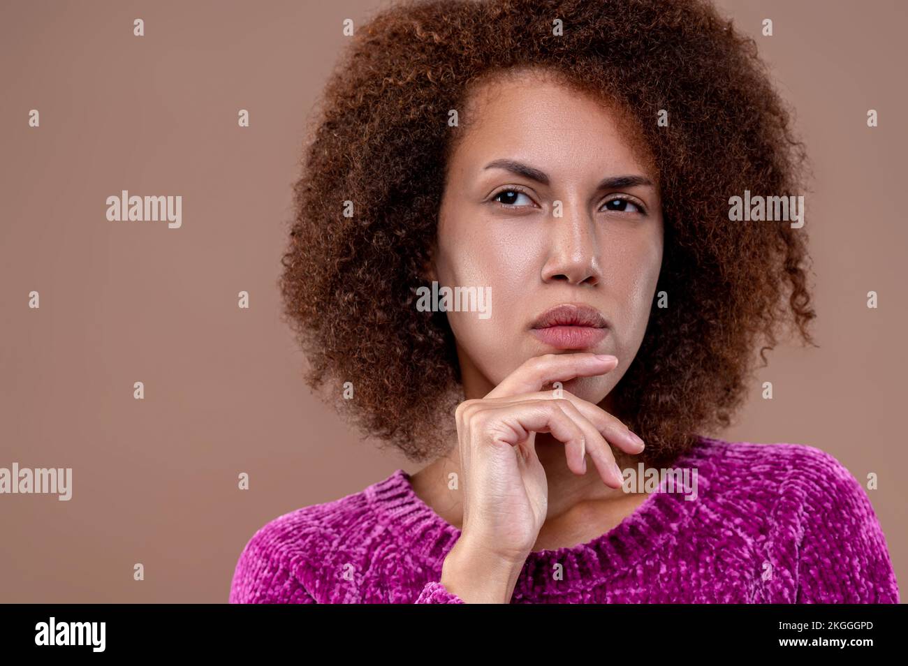 Dark-haired young woman looking thoughtful Stock Photo
