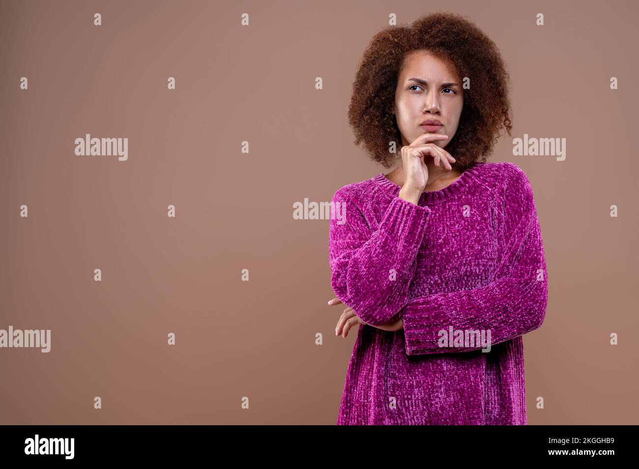 Dark-haired young woman looking thoughtful Stock Photo