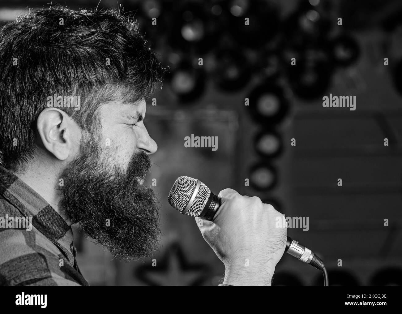 Musician with beard and mustache singing song in karaoke. Punk rock