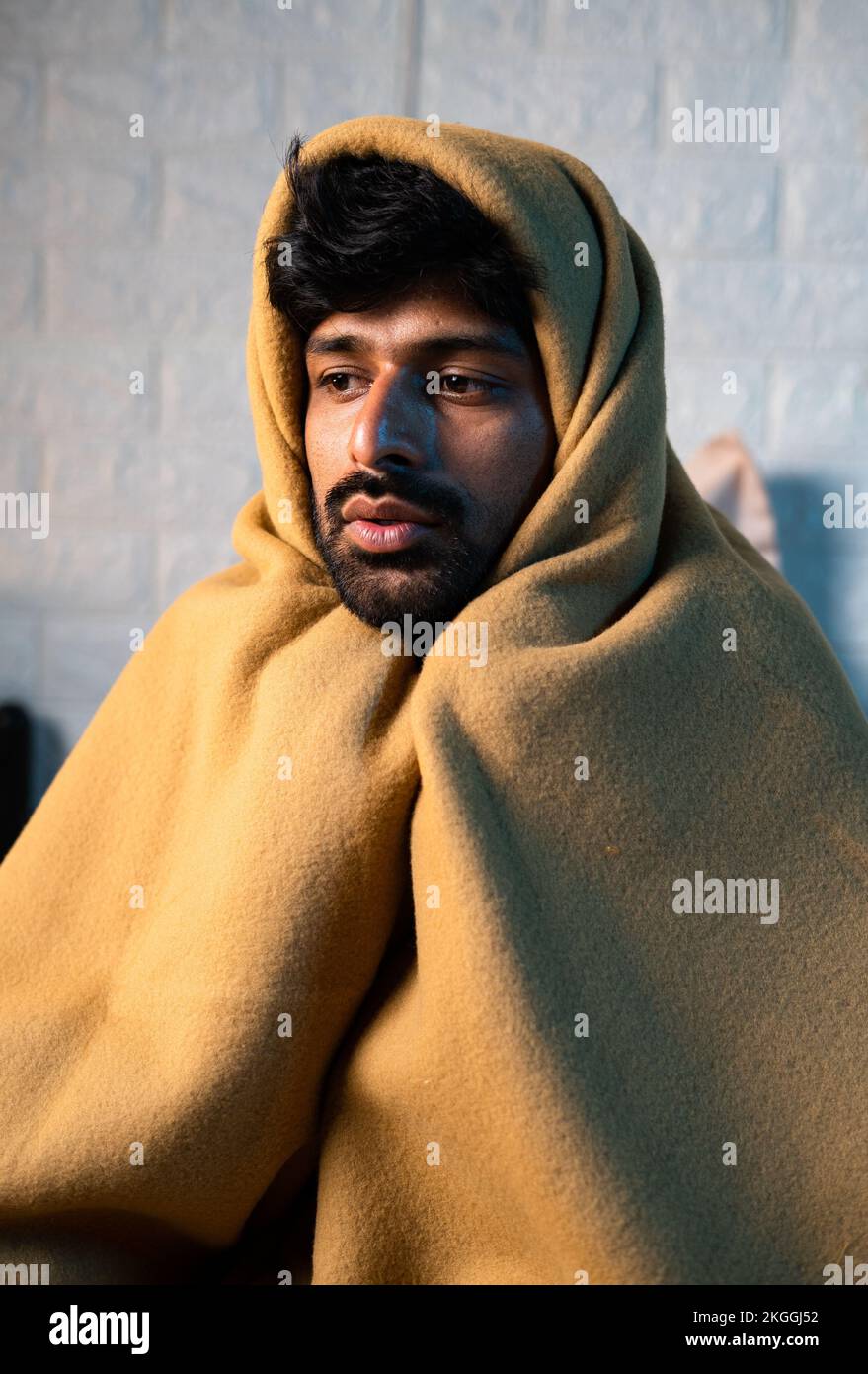 close up shot of Shivering young man woke up at night due to viral fever at night on bedroom during winter - concept of sick, fever and unwell. Stock Photo