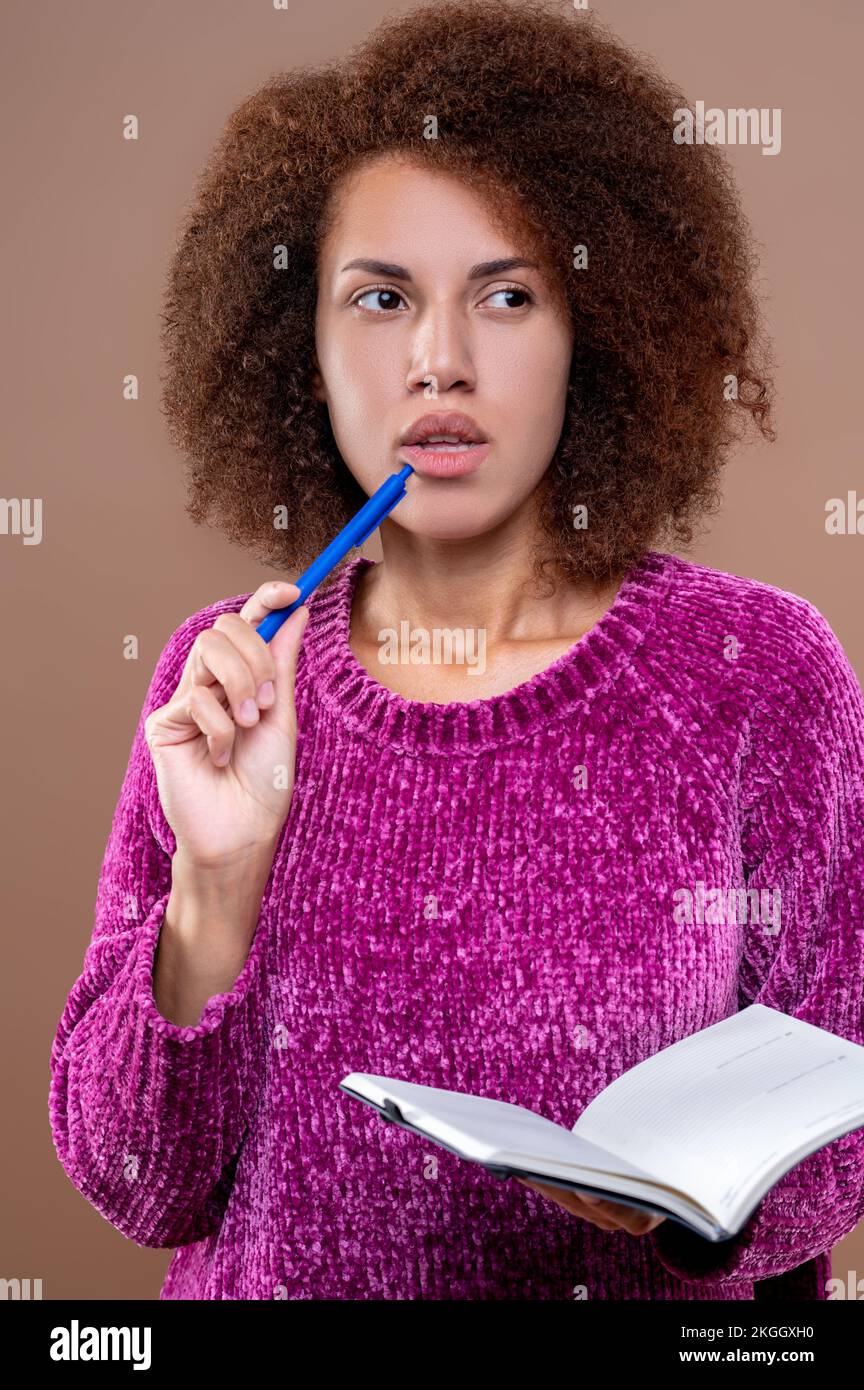 Young woman with a thoughtful look making notes Stock Photo - Alamy