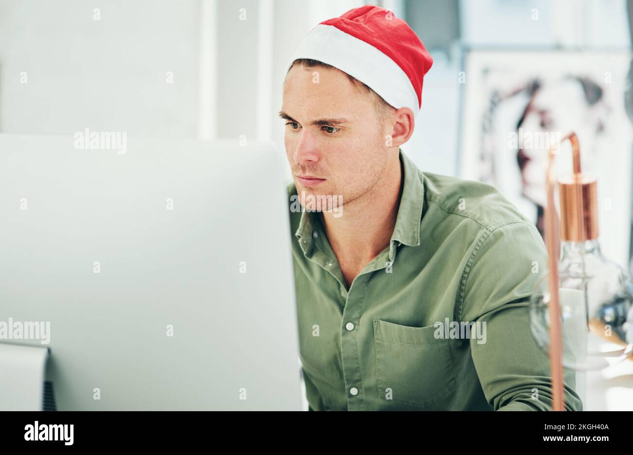 Businessman, computer and working with christmas hat in office at digital marketing job on internet. Man, holiday and work on pc, web or online with Stock Photo