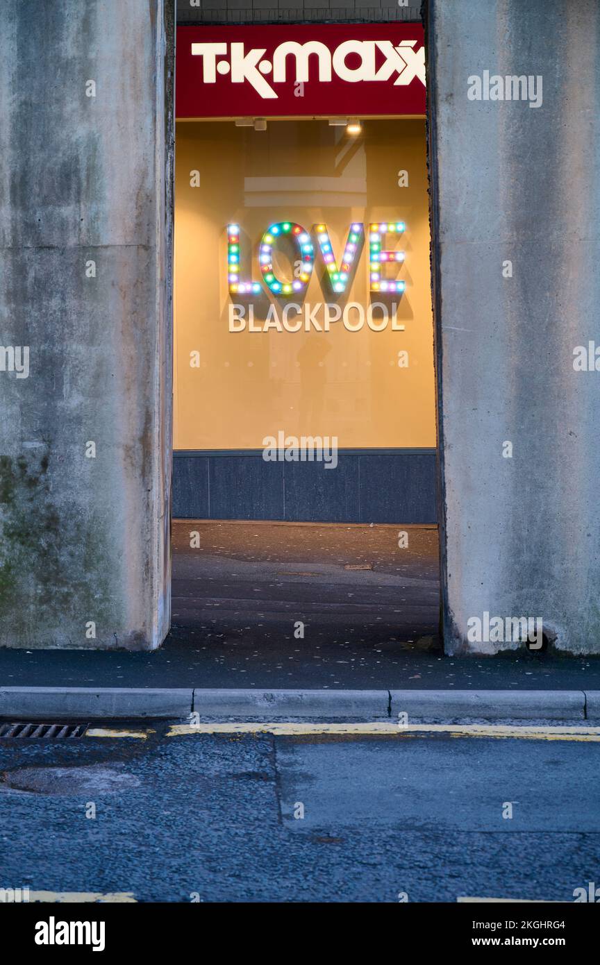 Illuminated Love Blackpool sign in town centre shop window at night
