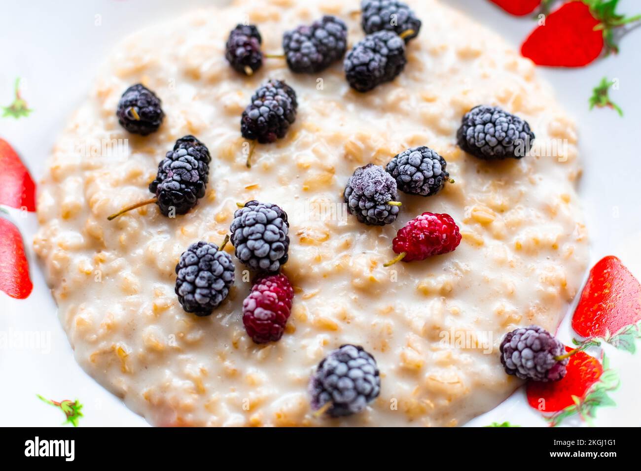 oatmeal with frozen mulberries. Delicious healthy breakfast. Close-up, selective focus. Stock Photo