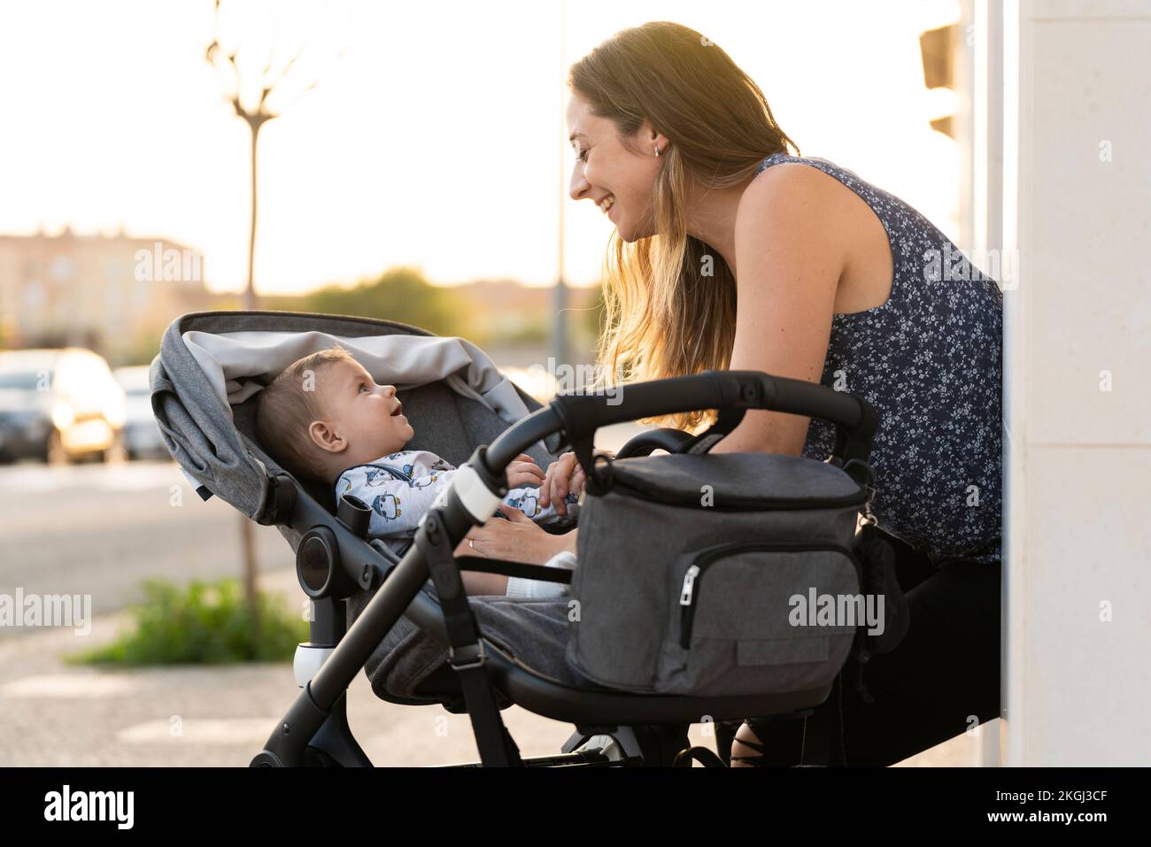 Mother and her son in the baby stroller at the door of their house Stock Photo