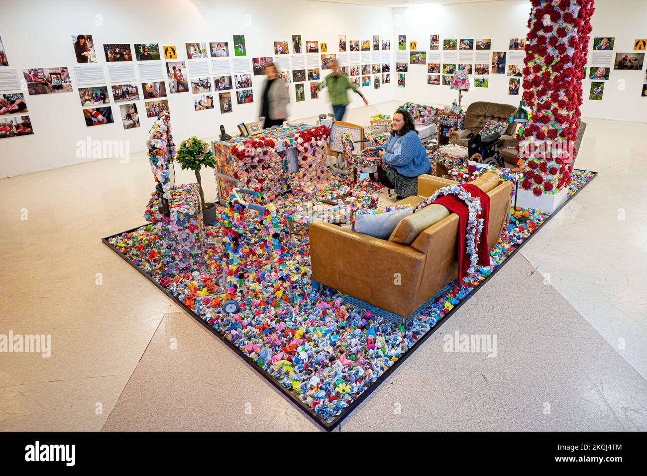 An installation of flowers created by carer Carina Andrews (pictured right) to mark Carers Rights Day on November 24, at the Galleries shopping centre in Broadmead, Bristol. The piece uses 40,138 paper flowers, each representing an unpaid carer in the Bristol area, with the flowers being made by carers and volunteers throughout 2022 and and cover a mock up of Carina's parent's living room. Picture date: Wednesday November 23, 2022. Stock Photo