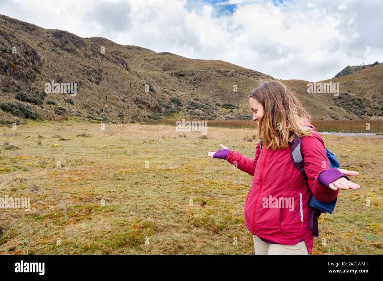 A female hiker lost in the Andean paramo shrugging her shoulders in Cajas National Park in the highlands of Ecuador, Cuenca, tropical Andes. Stock Photo