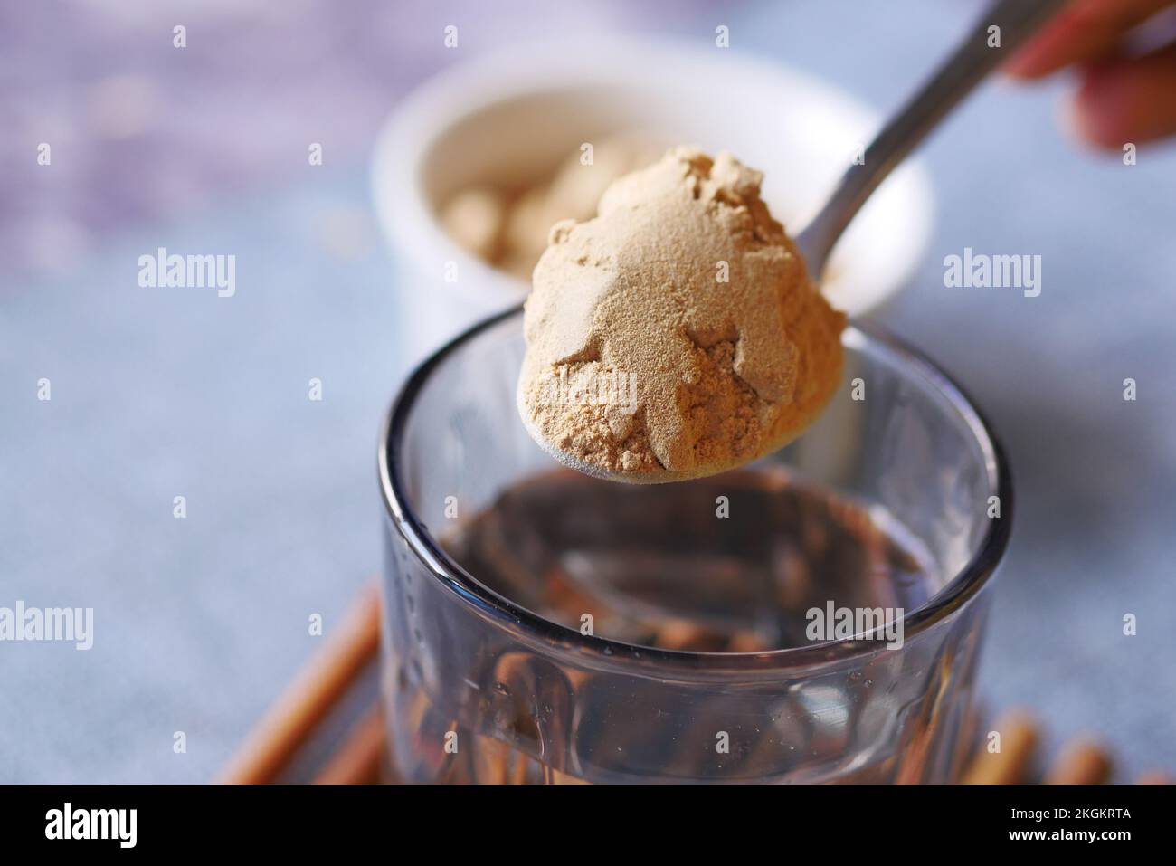 mixing brewers yeast flakes in a glass of water Stock Photo Alamy